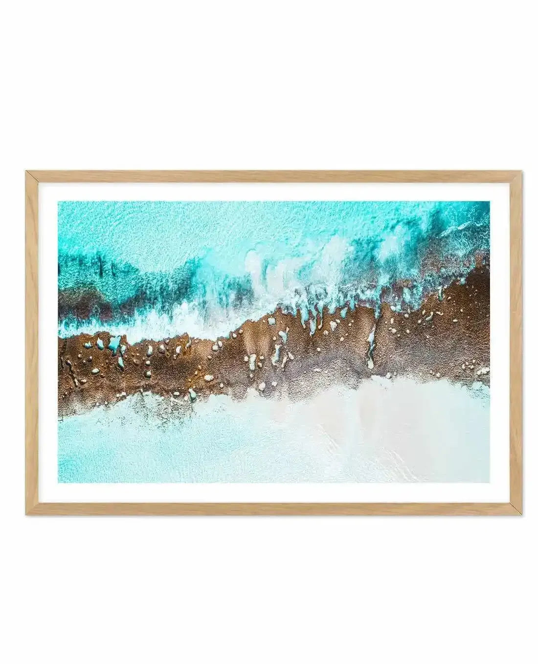 Aerial coastal photo in natural wood frame with white border, turquoise waves breaking over a sandy brown reef