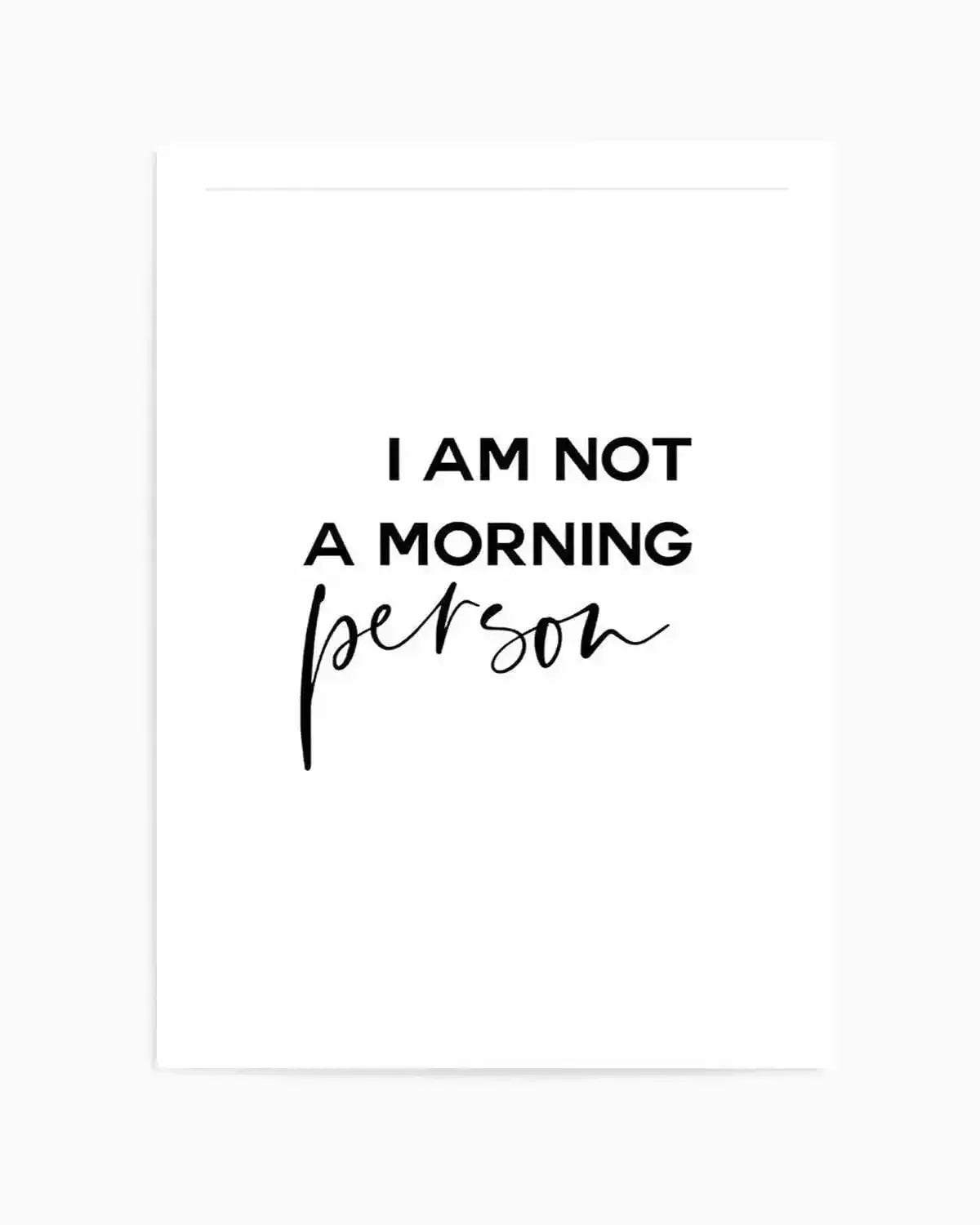 Art print featuring the phrase "I AM NOT A MORNING person" in black text on a white background. The words "I AM NOT A MORNING" are in a sans-serif uppercase font, while "person" is written in a flowing, handwritten script below it.
