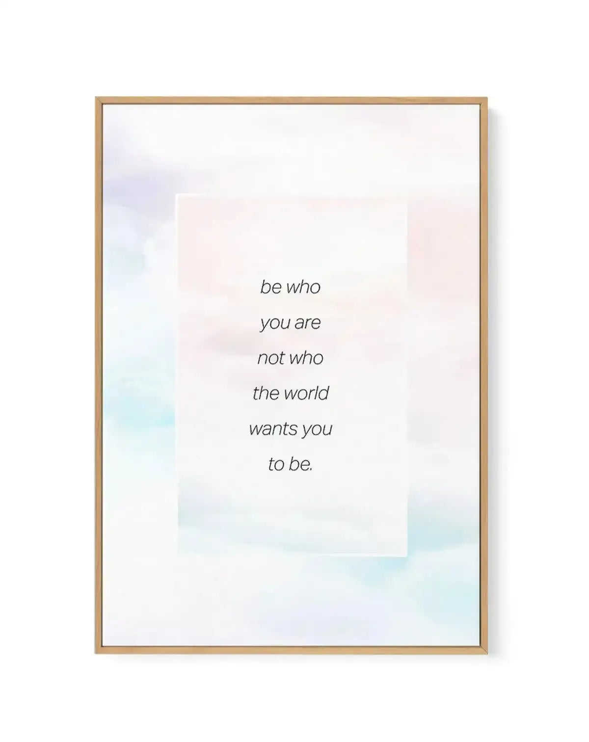 Framed canvas art print with natural wood frame featuring inspirational text reading "be who you are not who the world wants you to be" in italicized grey font, centered on white background with soft watercolor wash in pastel rainbow hues of blush pink, pale blue, mint green, and lavender blending across the composition.
