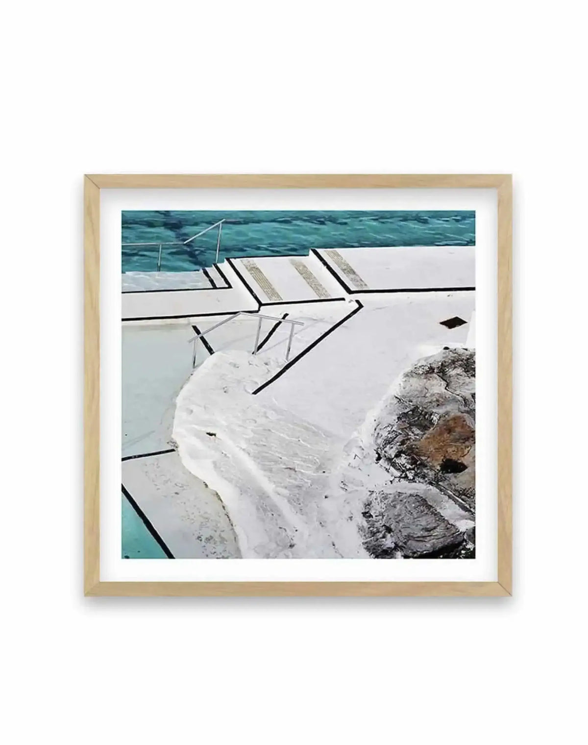 Framed square art print featuring a close-up photograph of a white motorboat docked beside turquoise water and rocky grey terrain. The boat's white hull and dark trim lines dominate the composition, with visible railings and deck features. Turquoise water and natural rock formations appear in the background. The photograph is mounted in a natural wood frame with a white border.
