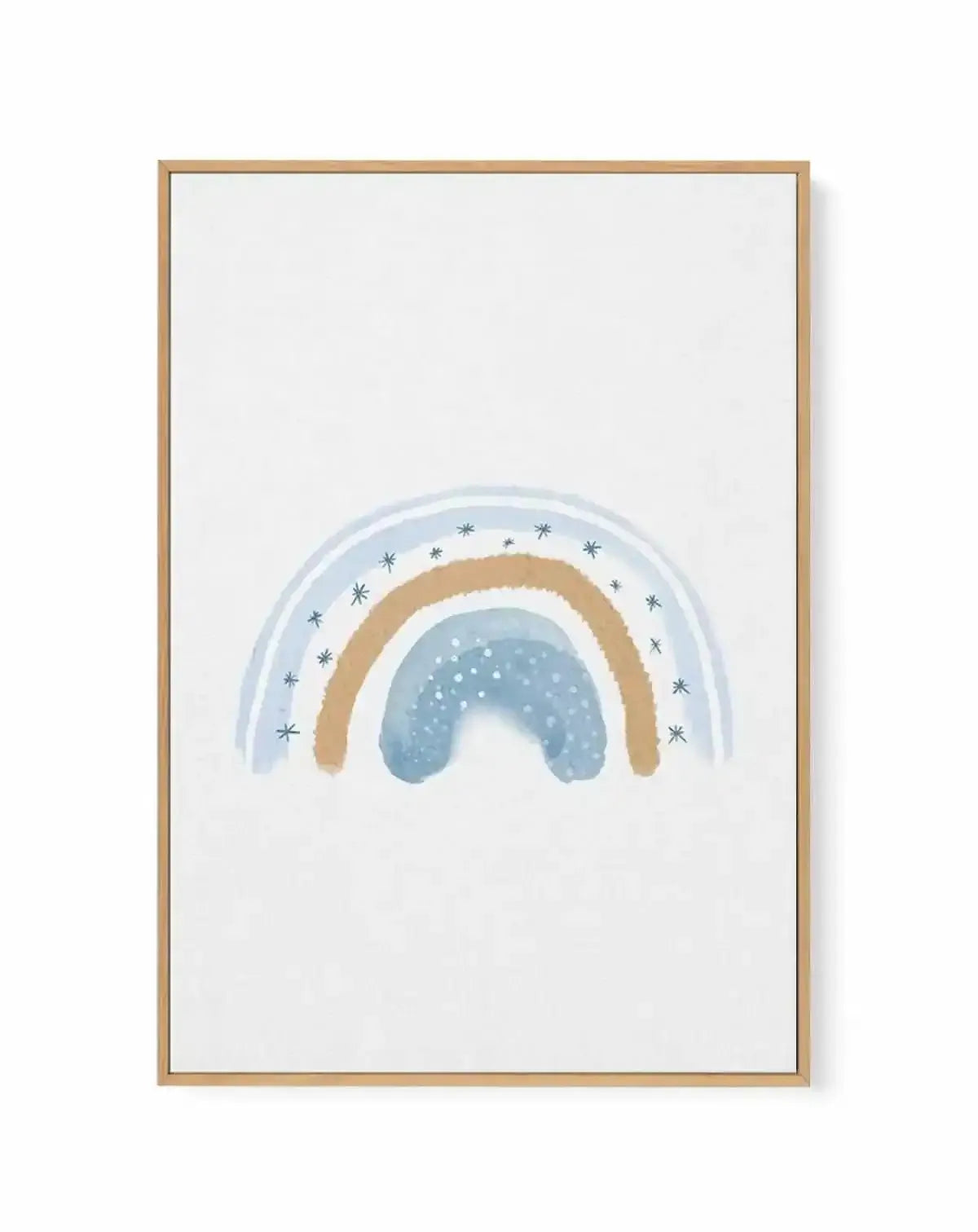 Framed canvas art print featuring a watercolor-style illustration of a dreamy rainbow with layered arcs in soft blue, tan, and white. The innermost arc is mist blue with white dots resembling falling snow or stars. The middle arc is warm tan or gold. The outer arc is pale blue decorated with small dark blue star symbols scattered around the curve. The artwork is centered on a white background and displayed in a natural wood frame with a white border.