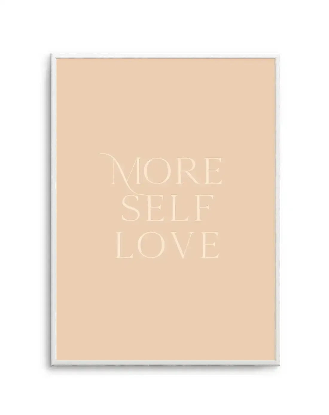 Art print featuring the words "MORE SELF LOVE" in a light cream serif font on a warm, pale peach background, displayed in a white frame with a white border.