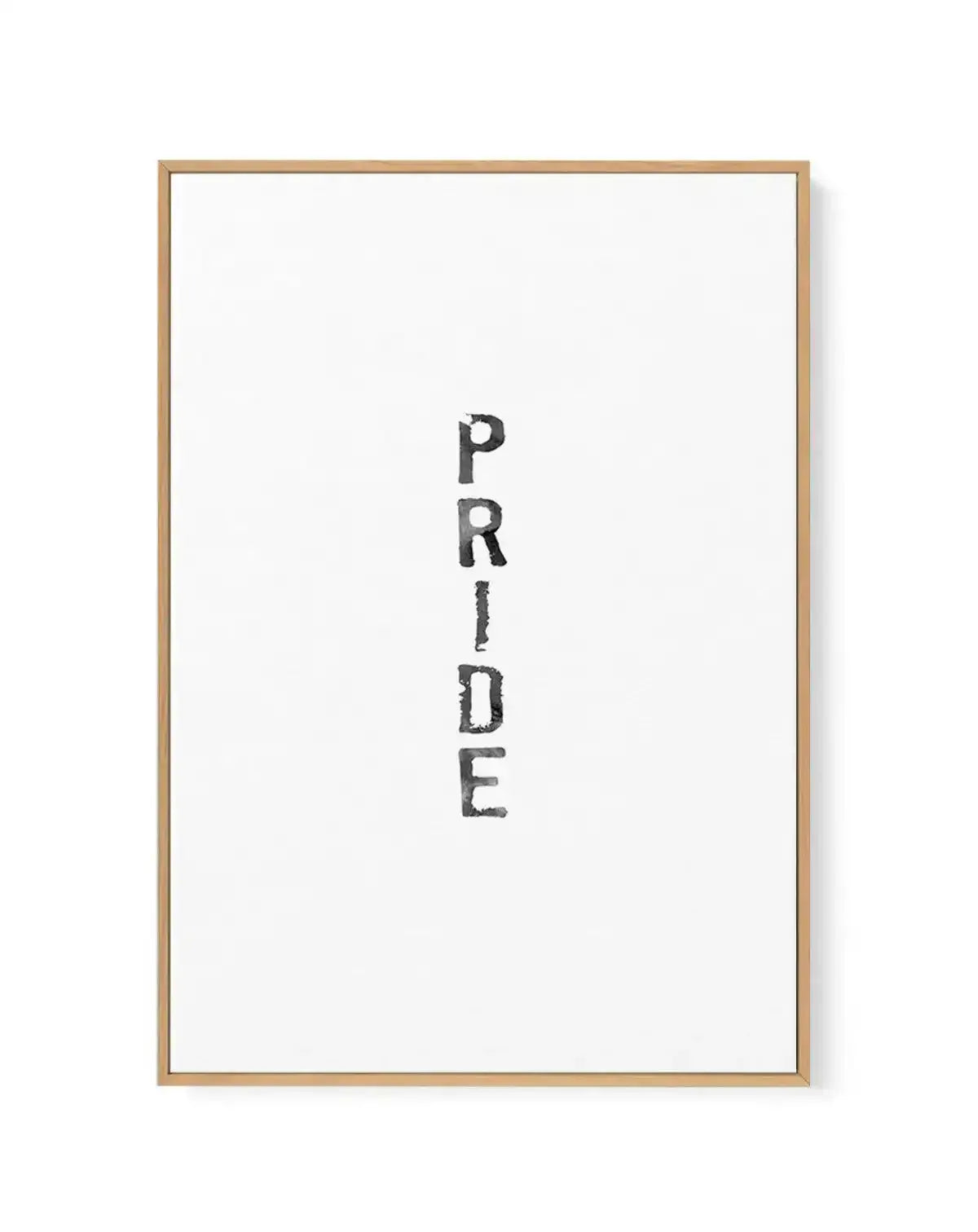 Framed canvas art print featuring the word "PRIDE" written vertically in black watercolour lettering with a textured, hand-drawn appearance on a white background. The canvas is set in a natural wood frame with a white border, displayed against a plain background with subtle shadow detail visible on the right edge.