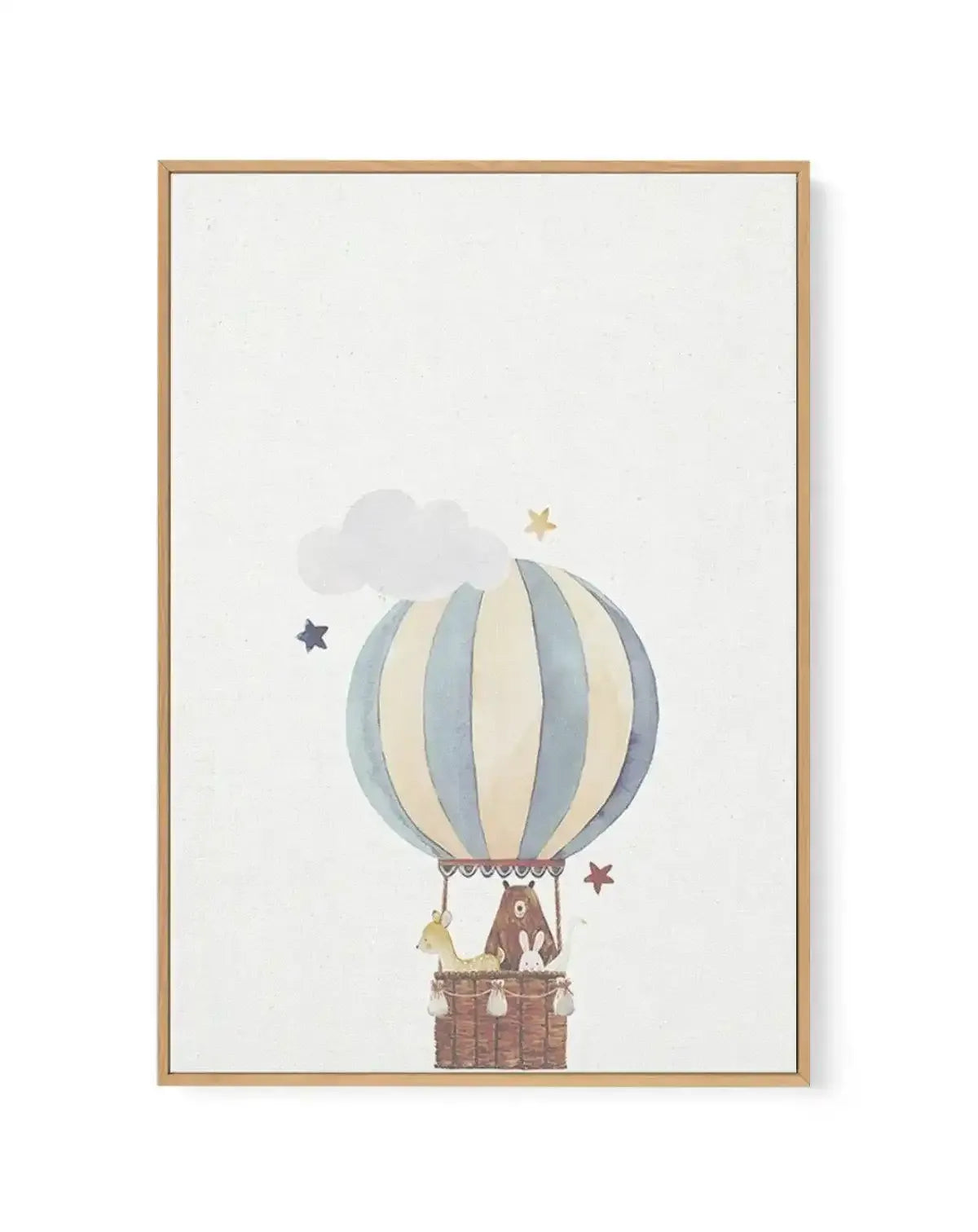 Framed canvas art print featuring a watercolor-style illustration of a hot air balloon with vertical stripes in soft blue-grey and cream tones, suspended above a wicker basket containing a bear and rabbit. A white cloud floats behind the balloon, with scattered stars in muted gold and dusty mauve nearby. Natural wood frame with white border against a pale cream background.