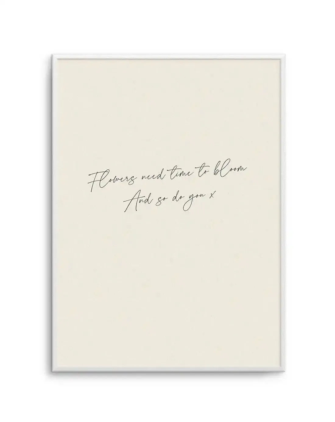 Art print featuring a handwritten script quote in black on a warm cream background, displayed in a white frame with white border. The quote reads: "Flowers need time to bloom And so do you x".