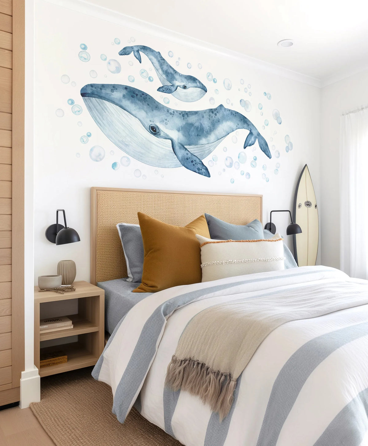 Watercolour humpback whale wall decals — navy and blue adult and calf with bubbles, styled in ocean-themed kids bedroom