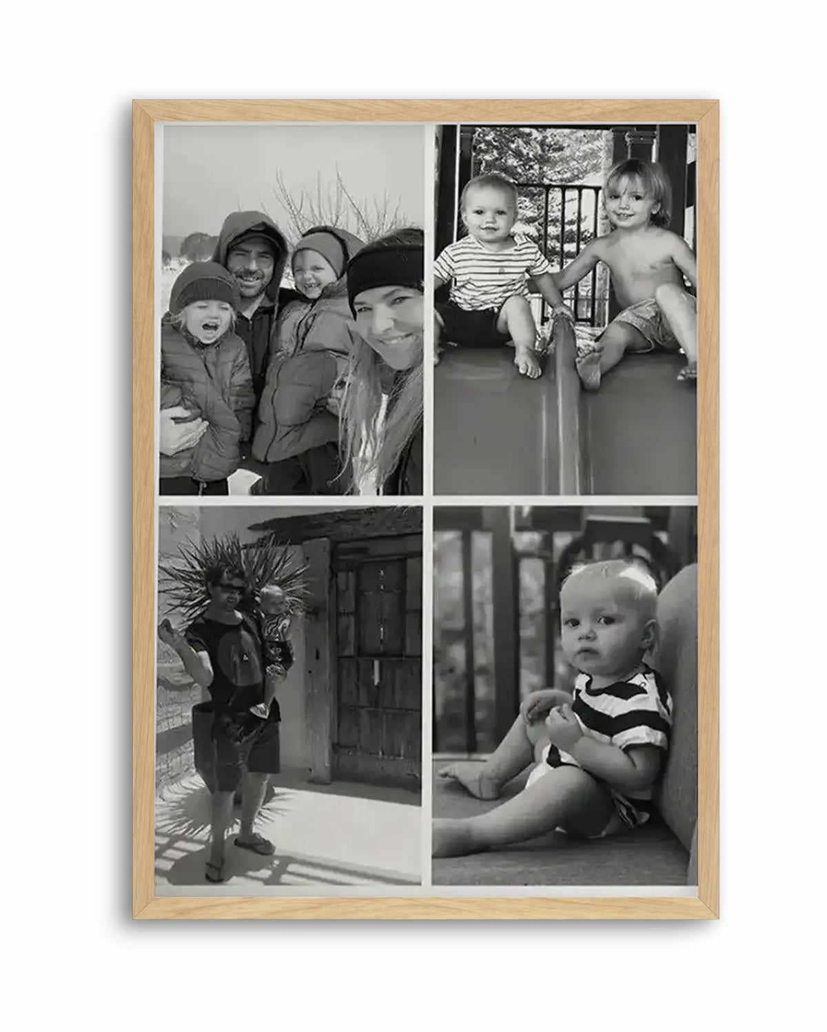 Framed black and white photography art print featuring a four-panel collage of family moments, displayed in a natural oak frame with white border. The top left panel shows a family of four bundled in winter clothes, smiling. The top right panel shows two young children, one in a striped shirt and one shirtless, sitting on a slide. The bottom left panel shows a man holding a baby, standing outdoors. The bottom right panel shows a baby in a striped shirt sitting on the floor.