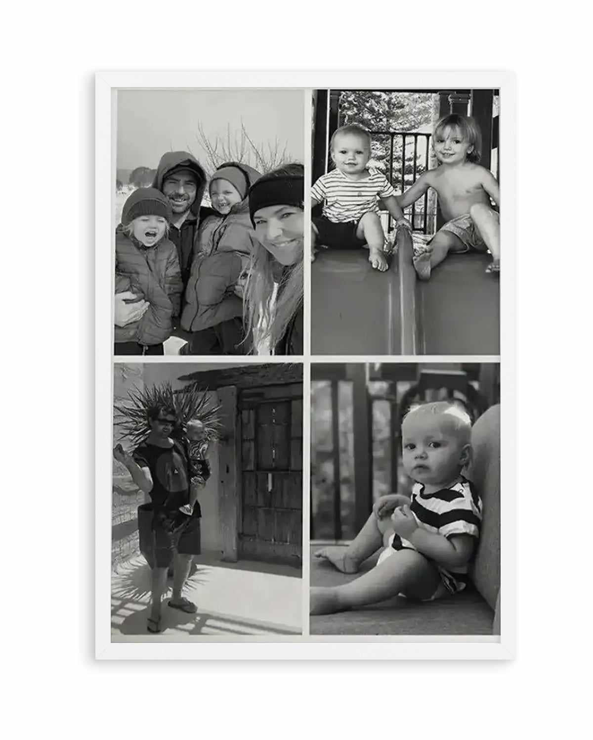 Framed black and white photography art print featuring four family photos in a grid layout, displayed in a white frame with white borders. The top left photo shows a family of four in winter clothing, smiling. The top right photo shows two young children sitting on a slide, one in a striped shirt and the other shirtless. The bottom left photo shows a man holding a baby, standing outdoors with spiky plants in the background. The bottom right photo shows a baby in a striped shirt sitting on the ground.