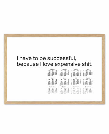 White calendar poster with bold black motivational quote above 12 monthly grids, in a natural wood frame