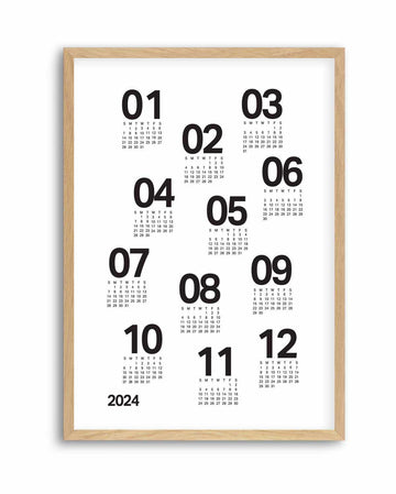 White 12-month scatter calendar poster with bold black numerals, in a natural wood frame