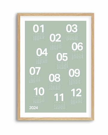 Sage green 12-month calendar poster with bold white numerals, in a natural wood frame with white border
