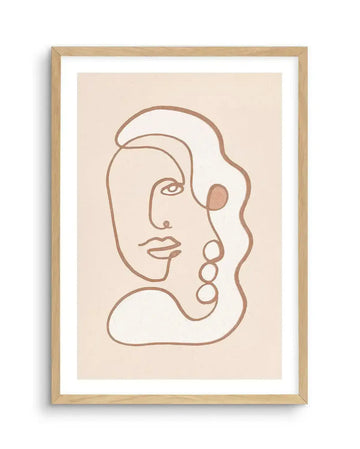 Abstract art print featuring a continuous line drawing of a stylized face in a warm, glittery bronze against a pale cream background, displayed in a natural oak frame with white border. The face is depicted in profile, with an eye, nose, and lips, and is integrated into a larger abstract shape with three circular elements on the right side.