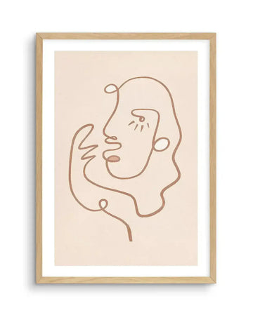 Abstract art print featuring a continuous line drawing of a face in a warm, muted terracotta hue against a creamy off-white background, printed on fine art paper and displayed in a natural oak frame with white border. The single line forms the profile of a face with an eye, nose, and mouth, and extends to suggest a hand near the chin.
