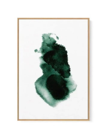 Abstract green watercolour paint blot artwork in portrait orientation, featuring organic ink wash shapes in varying shades of forest green, sage green, and black with soft diffused edges against a white background. The composition shows layered, fluid brushstrokes creating an ethereal, minimalist aesthetic. Mounted in a natural wood frame with a white border.