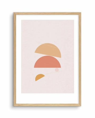 Abstract art print featuring three semi-circular shapes in warm, earthy tones on a pale pink background. The top shape is a large, light orange semi-circle, slightly tilted, with a faint white line crossing it. Below it is a larger, coral-pink semi-circle. At the bottom, a smaller, golden-yellow semi-circle is positioned to the left, with a faint white line and a small, translucent pink circle near it. The print is displayed in a natural oak frame with a white border.