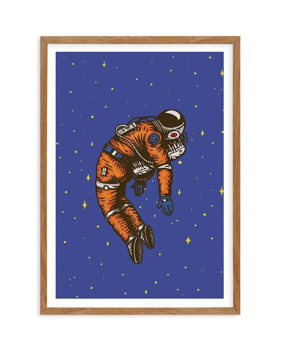 Art print featuring an illustration of an astronaut floating in space, depicted in an orange spacesuit with blue gloves against a deep blue background with scattered yellow stars. The astronaut appears to be in a relaxed, almost slumped pose, with visible details on the suit and helmet. The print is displayed in a natural oak frame with a white border.
