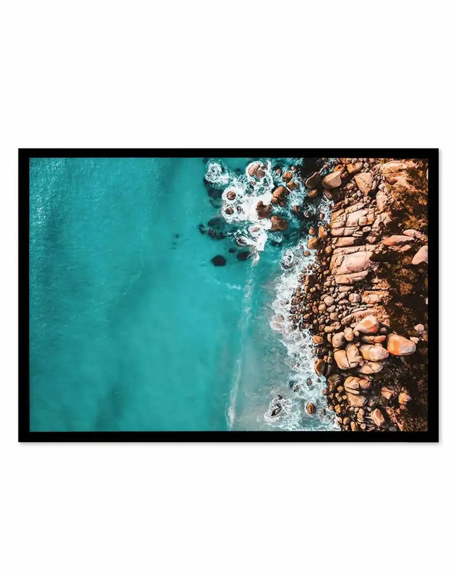 Aerial coastal print in black frame — turquoise ocean and brown rocky shoreline