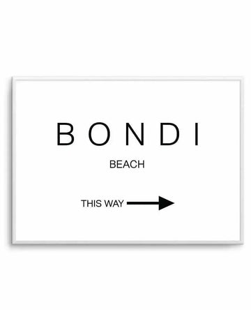 Minimalist art print with black text on white background. Large text reads "BONDI" at top, followed by "BEACH" underneath in smaller font. Below is "THIS WAY" with a black arrow pointing right. Design is mounted in a light gray frame with white border. Clean, modern aesthetic with ample white space.