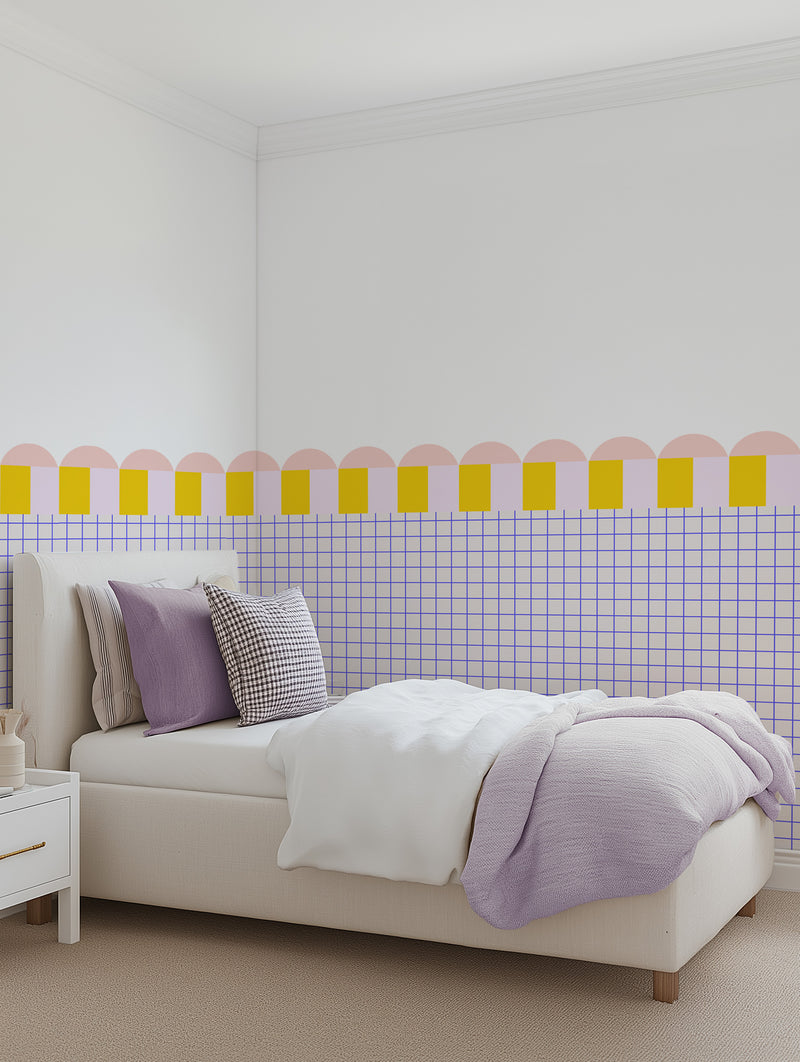 Bedroom with yellow, pink and blue scallop half-wall decal panel above cream bed — bright preppy style