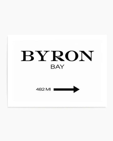 Byron Bay 482 MI Art Print displayed on a white background. The minimalist design features the text "BYRON" in large serif capital letters, with "BAY" in smaller sans-serif letters below. A black directional arrow points to the right next to "482 MI" in sans-serif text, suggesting distance or direction. The composition uses black text and graphics on a white paper background with a clean, modern aesthetic typical of travel or location-based wall art.
