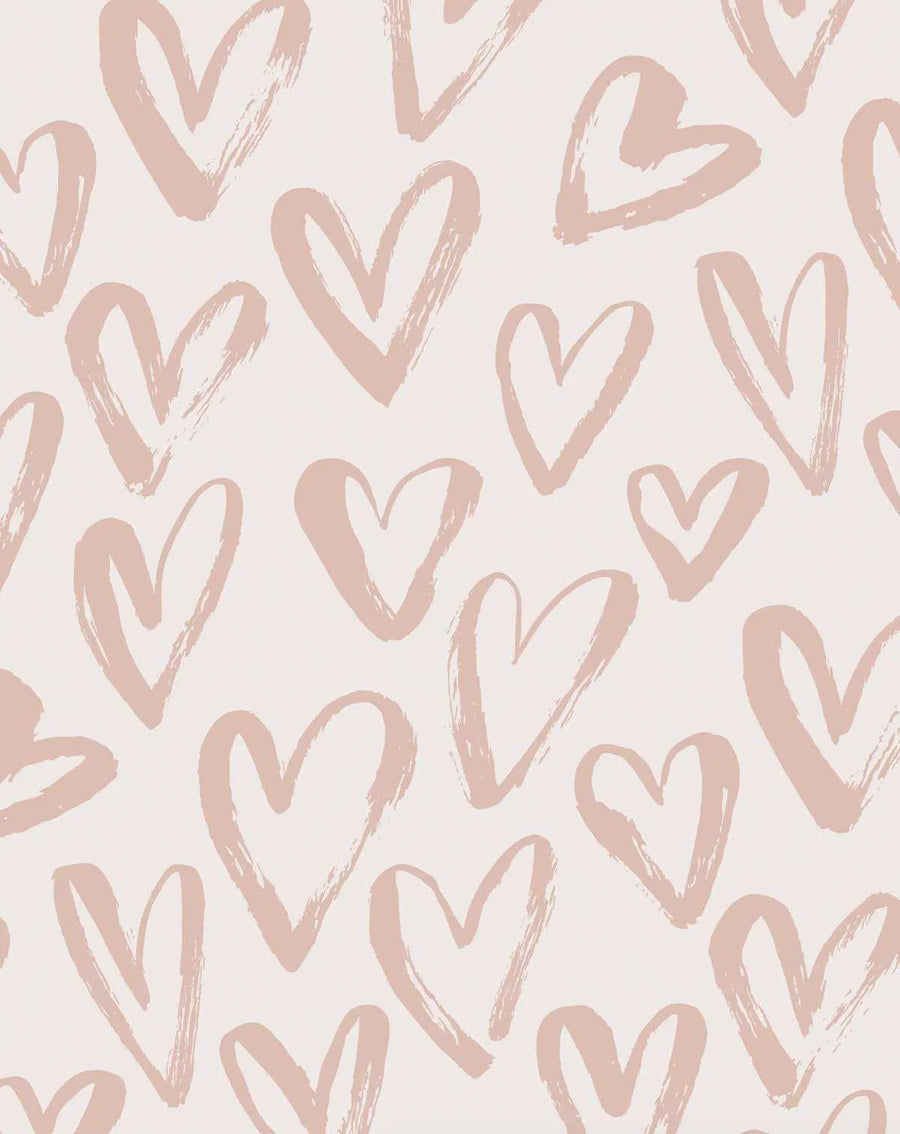 Peel and stick wallpaper featuring a repeating pattern of hand-painted hearts in a soft, dusty rose pink on a pale cream background. The hearts have a loose, organic brushstroke texture, varying in size and orientation across the design.