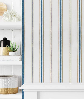 "Peel and stick wallpaper featuring a classic nautical stripe pattern with alternating thin and thick vertical stripes. The design includes thin dark blue and light brown stripes, and thicker teal blue stripes, all on a crisp white background with a subtle woven texture."