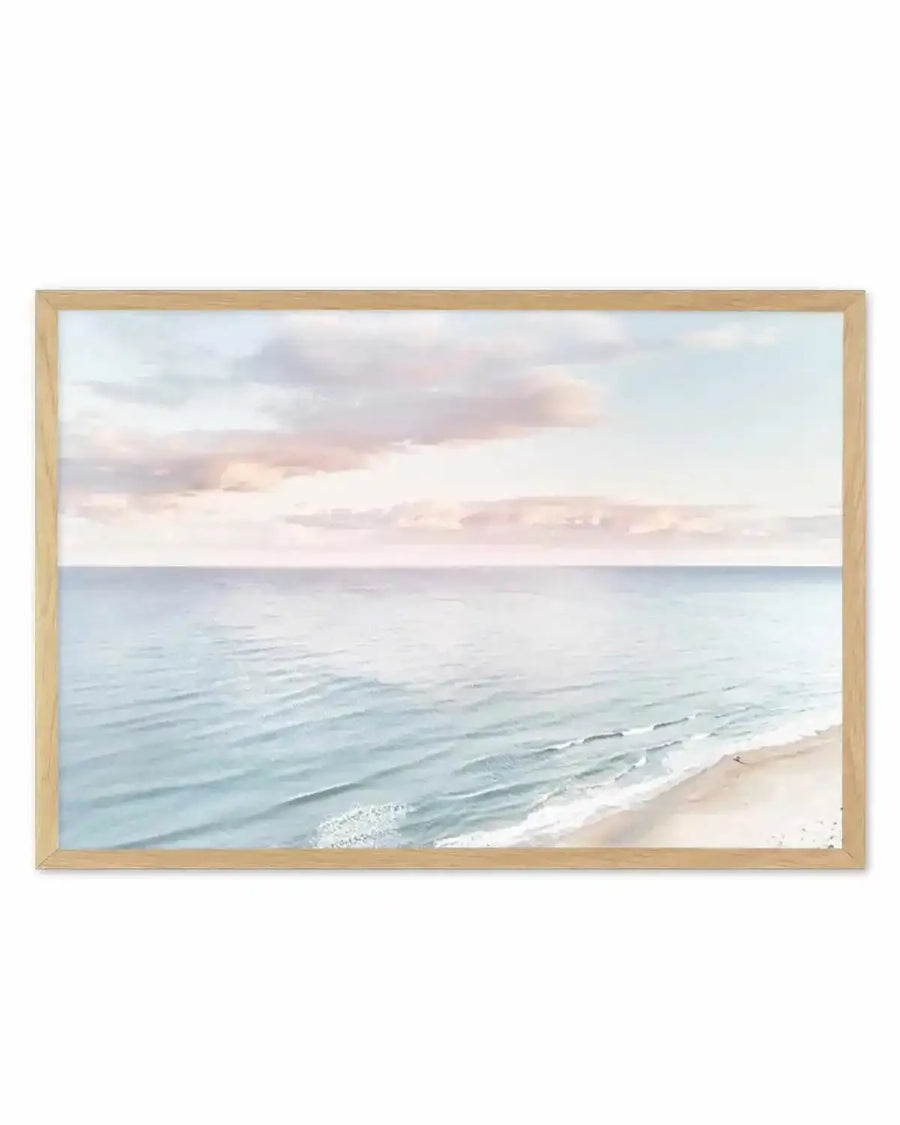 Pastel coastal seascape print in thin natural wood frame — soft blue ocean and sandy shore