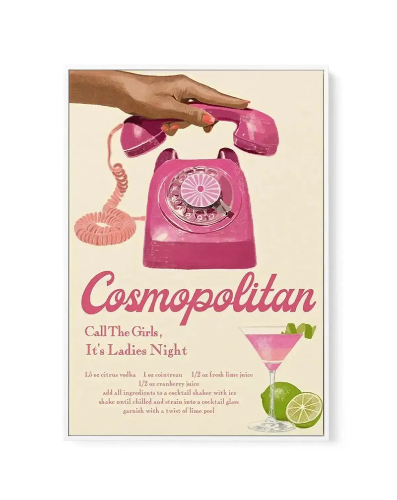 Framed canvas art print featuring a retro-style illustration of a woman's hand holding a pink rotary telephone receiver, with the phone base on a cream background. Below the phone, the word "Cosmopolitan" is written in a flowing pink script, followed by "Call The Girls, It's Ladies Night" in a smaller, elegant font. The bottom right shows a pink cosmopolitan cocktail in a martini glass, garnished with a lime peel twist, alongside two fresh limes. The print includes the cocktail recipe in fine print.