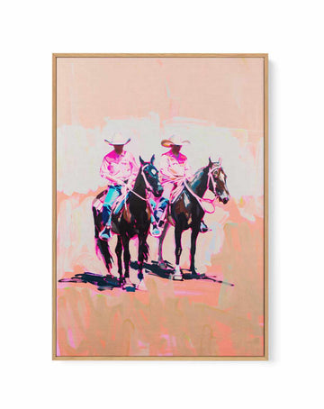 Canvas of two cowboys on dark horses in bold pink and magenta tones, natural wood float frame