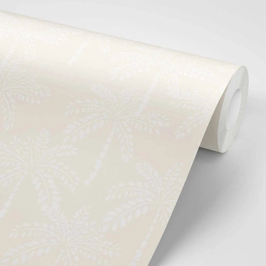 Peel and stick wallpaper featuring a repeating pattern of hand-drawn palm trees in white on a soft, sandy beige background. The tropical design has a clean, minimalist quality with visible texture on the paper.