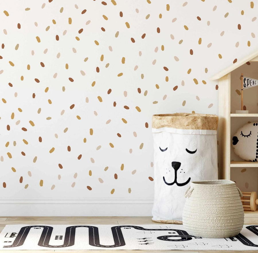 Boho dot decals in gold, brown and blush in kids playroom with wooden shelf and woven storage baskets