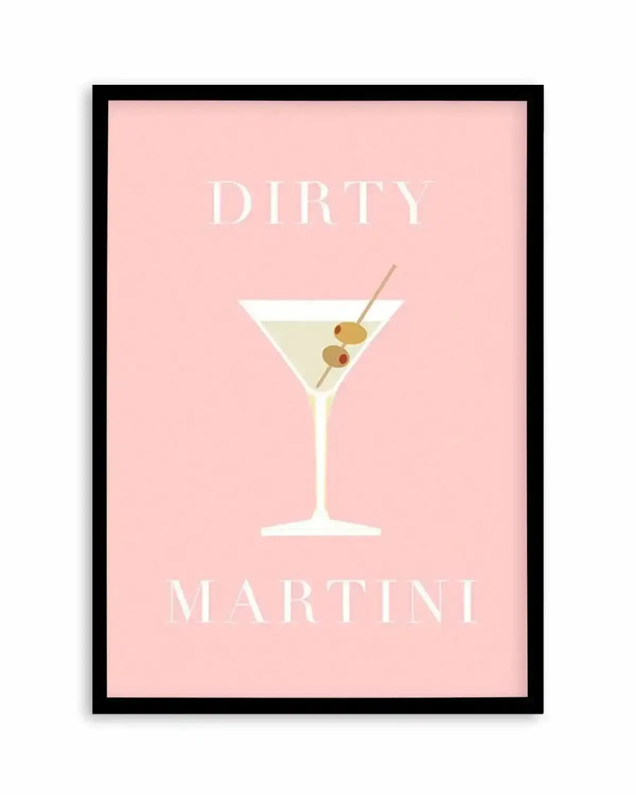 Art print featuring a minimalist illustration of a dirty martini cocktail on a pale pink background, displayed in a black frame with a white border. The martini glass is white with a pale yellow drink and two green olives on a toothpick. The words "DIRTY" and "MARTINI" are printed in white serif font above and below the glass.