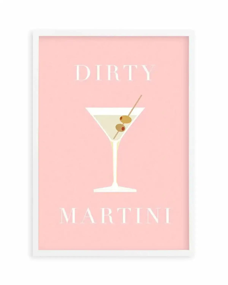Art print featuring a minimalist illustration of a dirty martini cocktail on a pale pink background, displayed in a white frame with a white border. The martini glass contains a pale yellow liquid and two green olives on a cocktail stick. The words "DIRTY" and "MARTINI" are written in a light cream serif font above and below the glass.