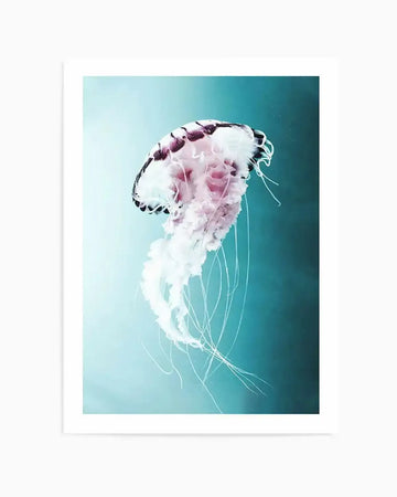Framed photography art print of a jellyfish with a white border. The jellyfish has a translucent bell with dark purple markings and delicate, flowing white tentacles, set against a gradient background transitioning from light teal to a deeper blue.