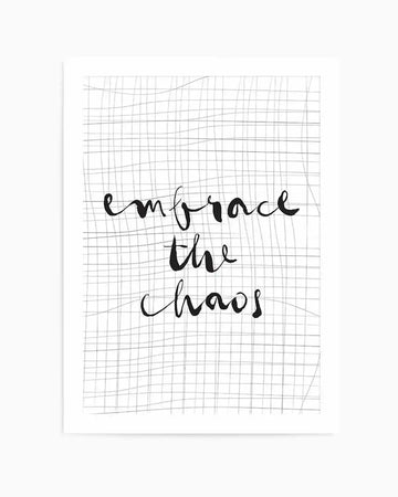 Art print featuring handwritten script text reading "embrace the chaos" in black ink on a white background with an overlay of a distorted grid pattern that creates a warped, dimensional effect. The print is mounted in a white frame with a white border.