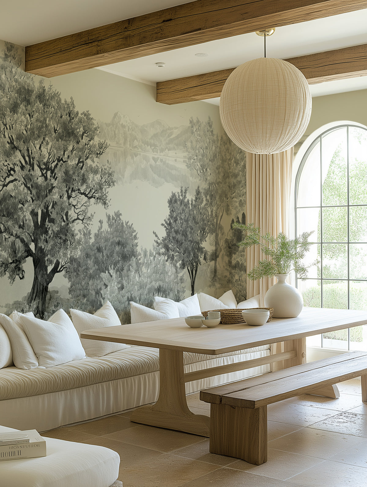 Neutral dining room with grey-green European countryside panoramic mural wallpaper, wood beams and white banquette