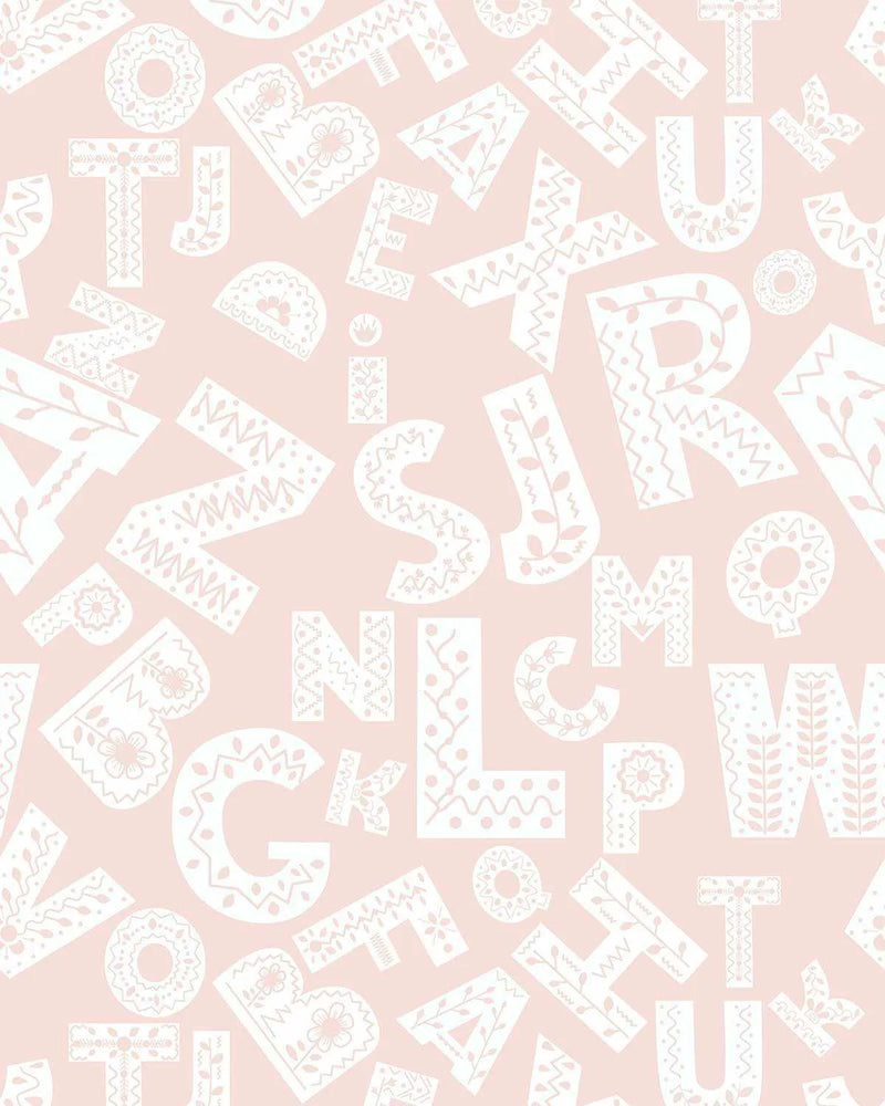 Peel and stick wallpaper featuring a repeating pattern of decorative alphabet letters in white on a soft blush pink background. The letters are in various sizes and orientations, each filled with unique folk-art inspired patterns like flowers, leaves, waves, and geometric shapes, creating a whimsical and intricate design.