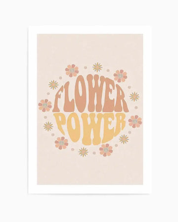 Art print featuring the words "FLOWER POWER" in a retro, wavy font, with "FLOWER" in a muted peach and "POWER" in a soft golden yellow. The text is surrounded by a circular arrangement of stylized flowers with six petals in shades of peach, pink, and light orange, interspersed with small, simple starburst shapes in a pale yellow. The background is a textured, light cream colour.