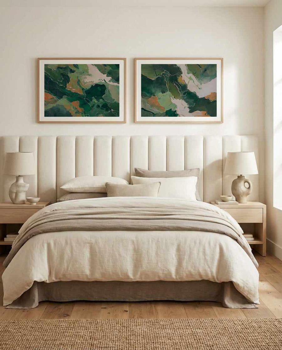 Forest Vein I art print displayed in a natural wood frame with white border, hung above a cream upholstered bed headboard. The abstract artwork features deep forest green, sage green, and warm ochre tones in an organic, flowing composition suggesting aerial landscape or topographical patterns. Framed print shown in a serene, minimalist bedroom with natural light, cream bedding, wooden nightstands, ceramic table lamps, and a neutral jute area rug.