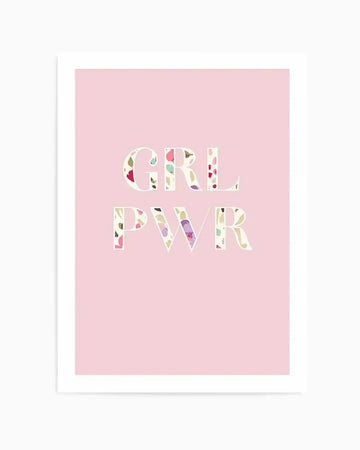 "Art print featuring the words 'GRL PWR' in large, uppercase letters with a colourful floral pattern filling each letter, set against a soft pastel pink background. The floral pattern includes small, abstract shapes in shades of pink, purple, yellow, and green, giving a watercolour-like texture. The print is displayed in a white frame with a white border."