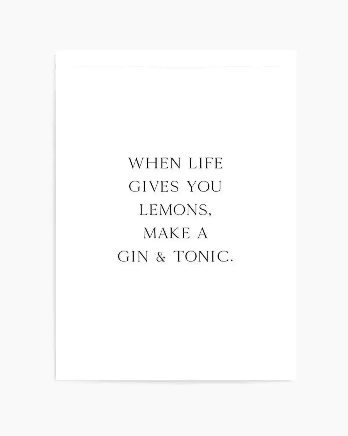 Minimalist art print with black serif typography centered on a white background reading "WHEN LIFE GIVES YOU LEMONS, MAKE A GIN & TONIC." The text is evenly spaced across the composition in a classic, elegant font. The print appears to have a subtle border and clean, unframed presentation against a light cream or off-white paper.