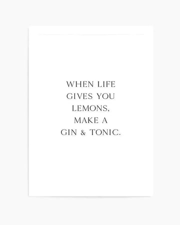 Minimalist art print with black serif typography centered on a white background reading "WHEN LIFE GIVES YOU LEMONS, MAKE A GIN & TONIC." The text is evenly spaced across the composition in a classic, elegant font. The print appears to have a subtle border and clean, unframed presentation against a light cream or off-white paper.