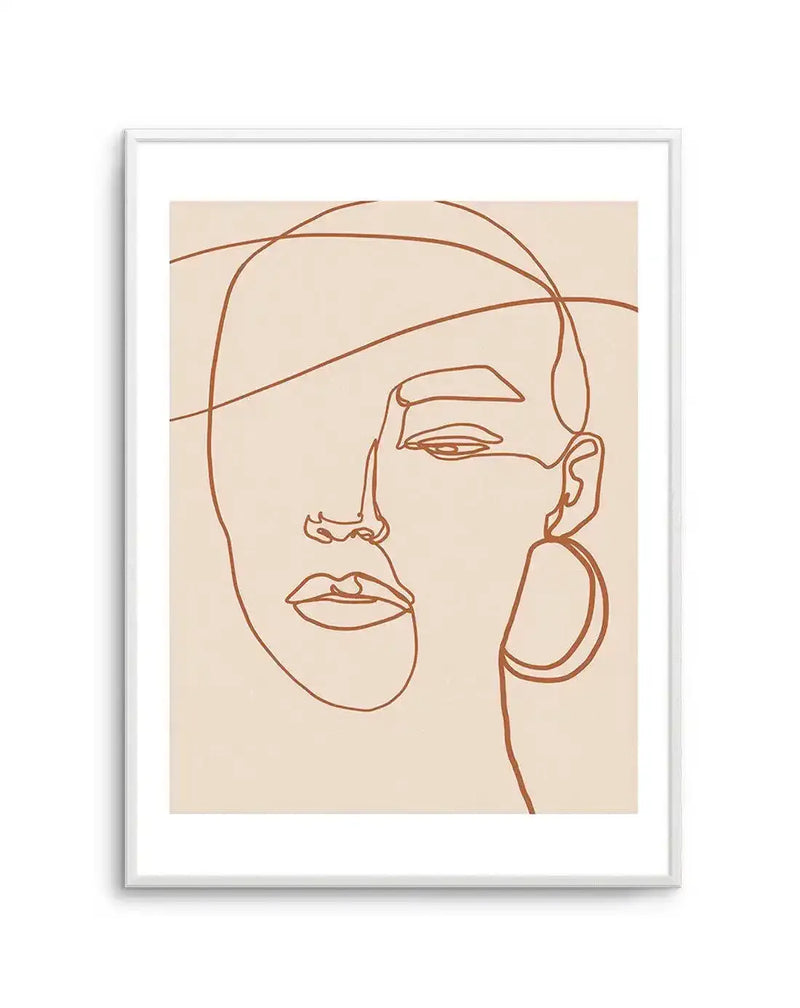 Line art print featuring a minimalist abstract portrait of a woman's face in terracotta brown on a cream background, displayed in a white frame with a white border. The continuous line drawing depicts a partial face with an eye, nose, and lips, and a large hoop earring on the right side.