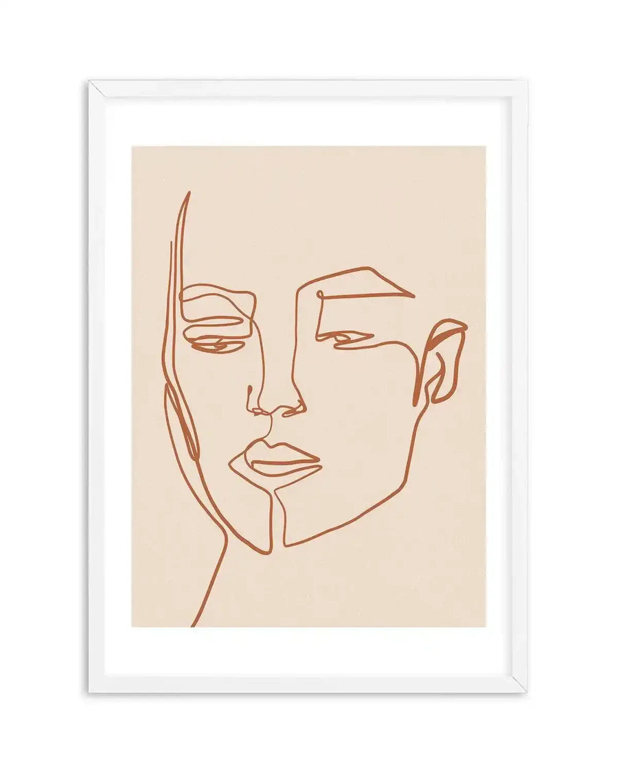 Line art print featuring a minimalist illustration of a woman's face in a continuous terracotta-coloured line on a warm cream background, printed on fine art paper and displayed in a white frame with white border. The composition shows the woman's face from the nose down, with one eye partially visible and the other implied.