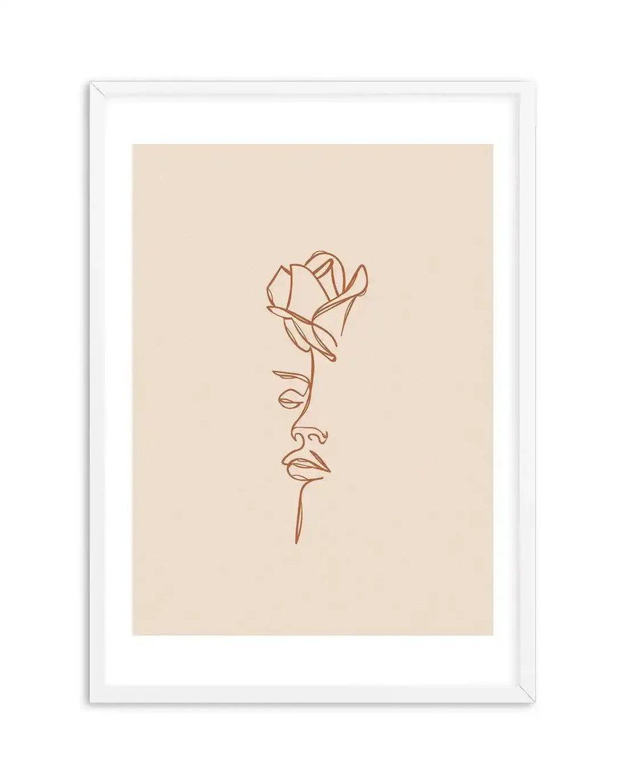 Line art print featuring a continuous terracotta line forming the profile of a woman's face from the forehead to the chin, with a rose blooming from her temple, on a warm cream background, displayed in a white frame with white border.