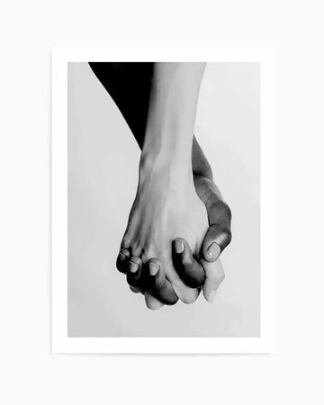 Black and white photograph of two hands, one light-skinned and one dark-skinned, clasped together in a gesture of unity and connection, printed on fine art paper.