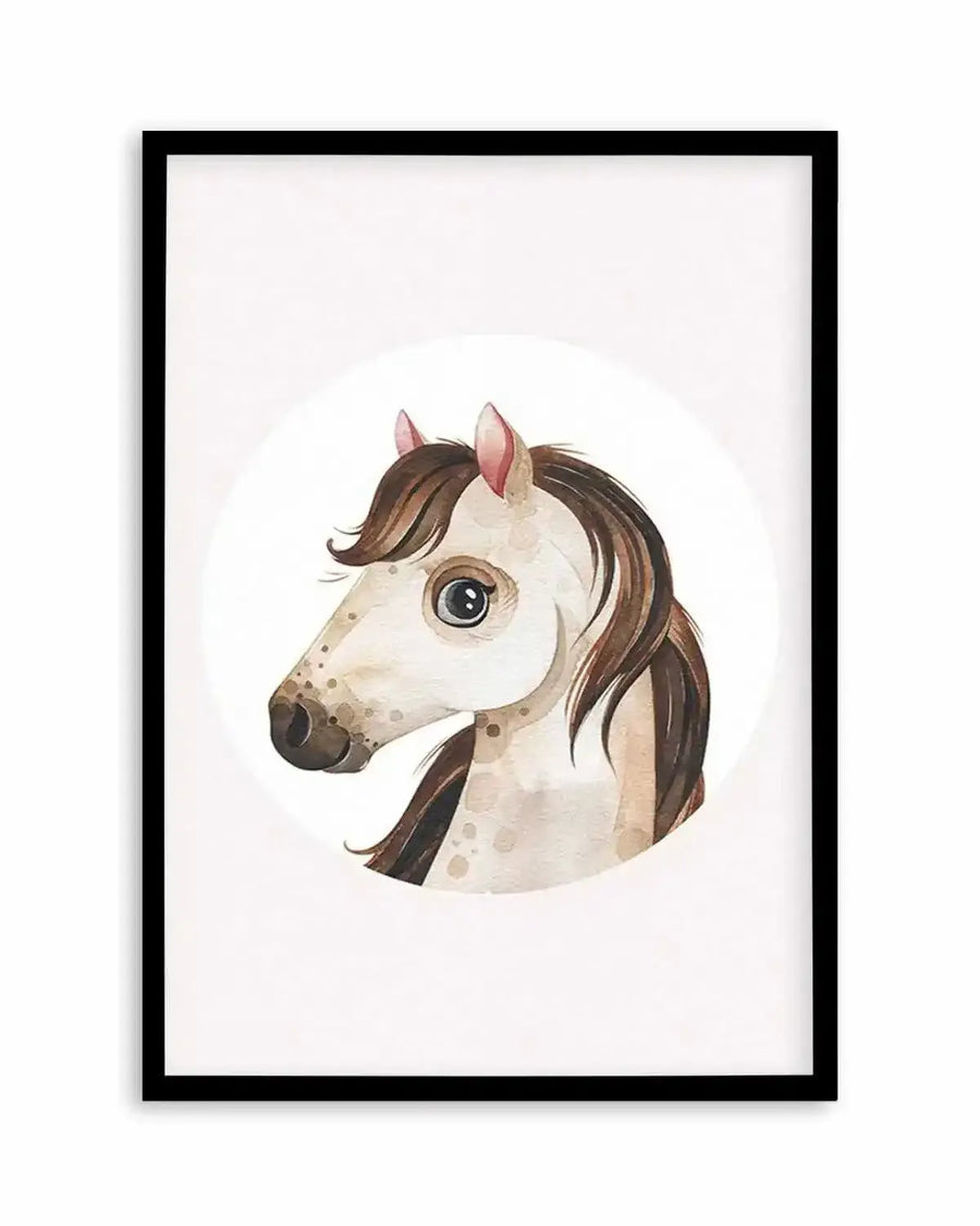 Watercolour art print featuring the head of a cartoon-style horse with large, dark eyes and a brown mane, set against a white circular background and displayed in a black frame with a white border. The horse has light brown fur with darker brown spots and pink inner ears.