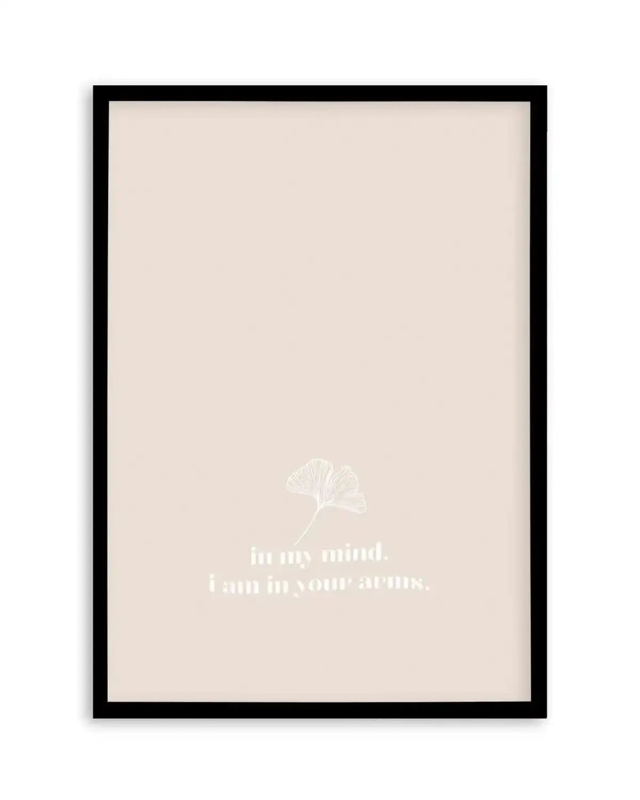 Framed art print with black frame featuring a cream background with a delicate white line illustration of a ginkgo leaf in the upper center. Below the leaf, white serif text reads "in my mind. i am in your arms." The minimalist design has a soft, contemplative mood with subtle texture visible on the cream surface.