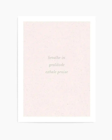 Art print featuring the words "breathe in gratitude exhale praise" in a delicate, light green script on a soft, speckled blush pink background.
