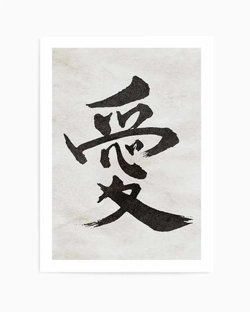 Japanese calligraphy art print featuring black brushstroke characters stacked vertically on a cream textured background, representing the word "love." The characters are rendered in bold, expressive black ink with organic, hand-painted edges and varying stroke widths. The print is presented with a clean white border frame. The overall composition has an artistic, minimalist aesthetic with high contrast between the dark calligraphy and light background.